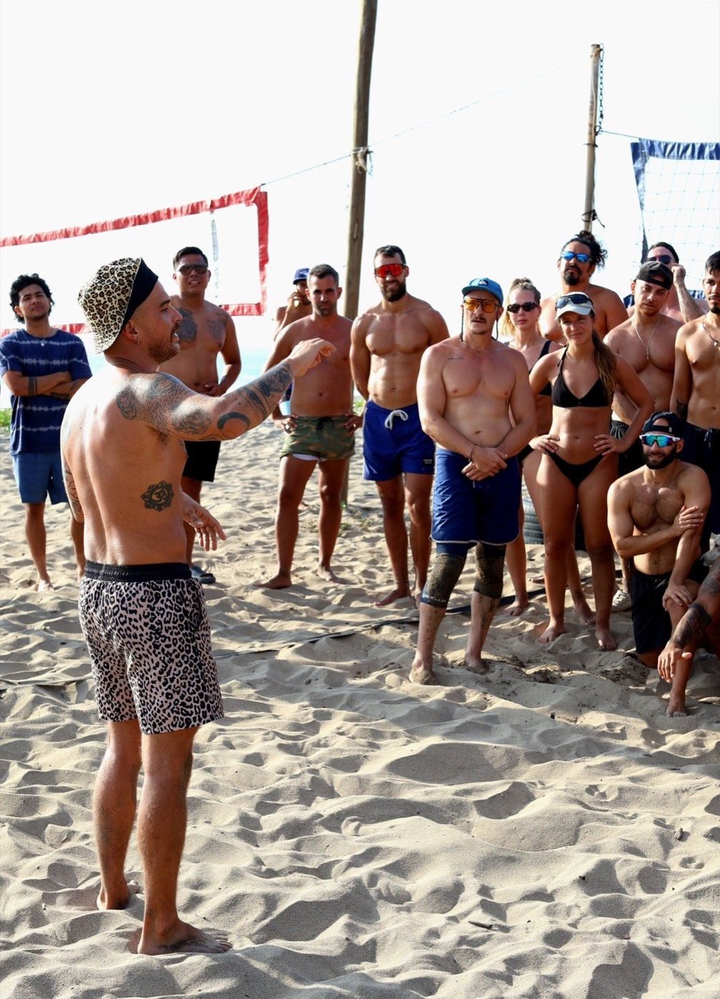 A coach gesturing to a group of players listening on the beach in Puerto Escondido.