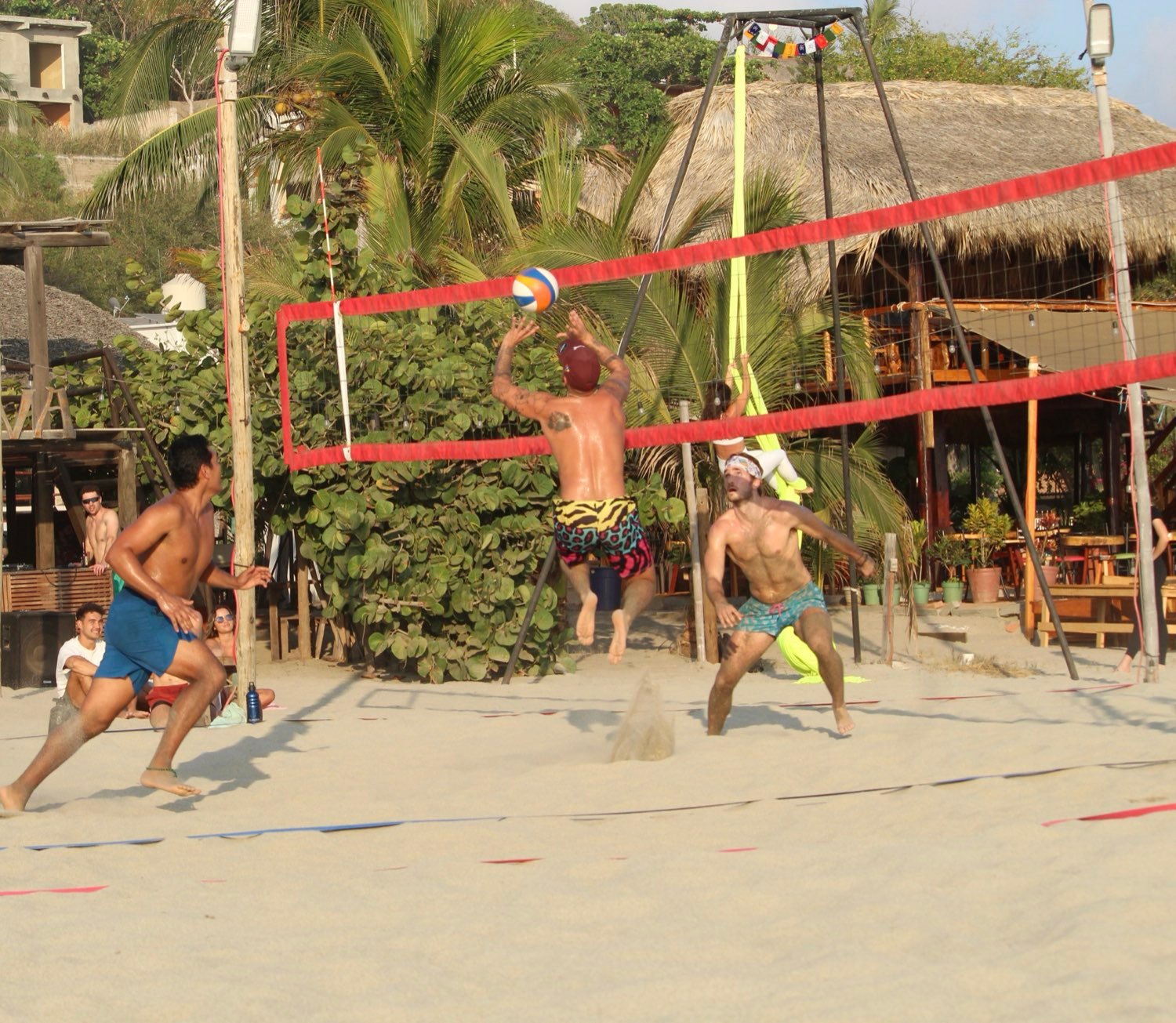 A player jumping to hit the ball at the net, beachfront court in Puerto Escondido.