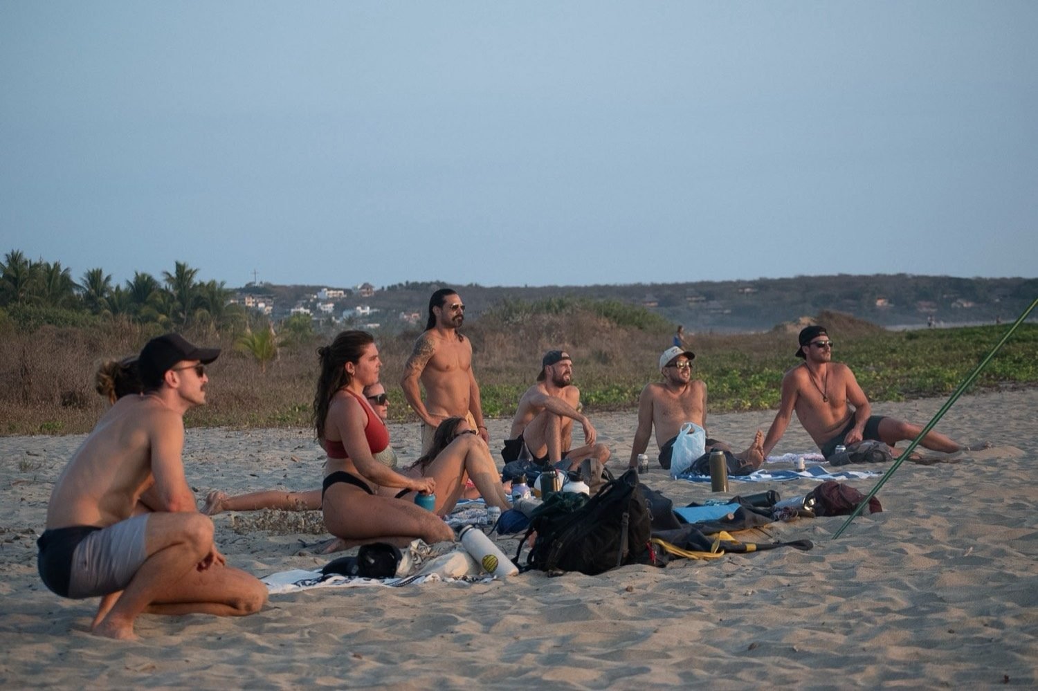 A group sitting together on the sand at the end of a session.